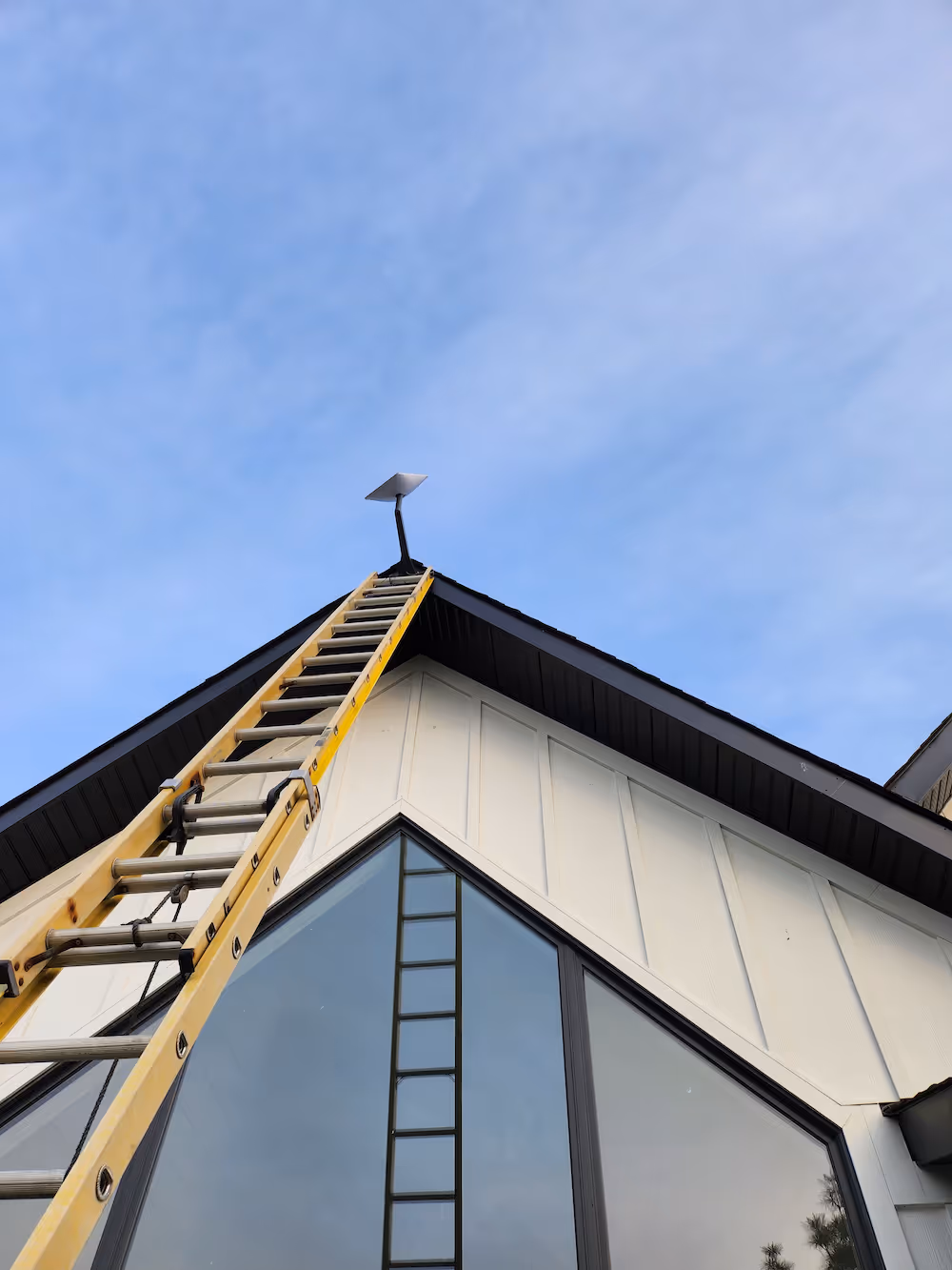 j-arm starlink installation at the top of a tall peaked roof